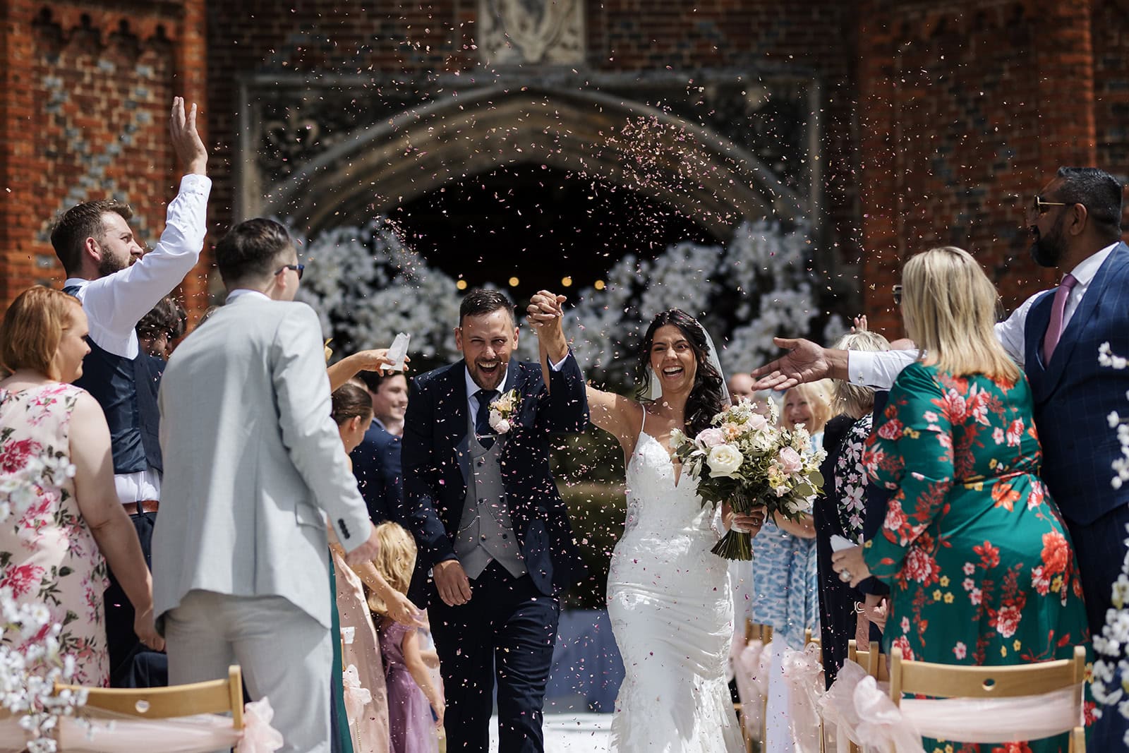 Elegant confetti shot with bride and groom surrounded by joyful guests at Leez Priory
