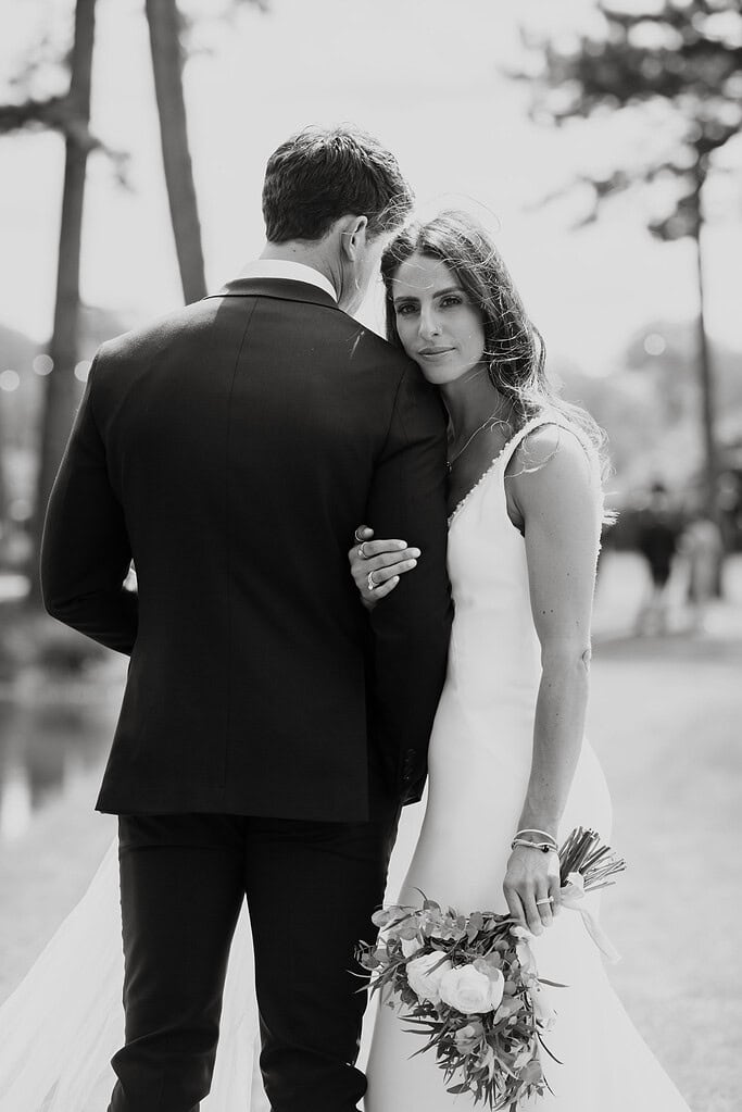 Editorial wedding photography; bride and groom unconventional portrait; groom facing away and bride looking back at camera; luxury modern wedding style Essex.